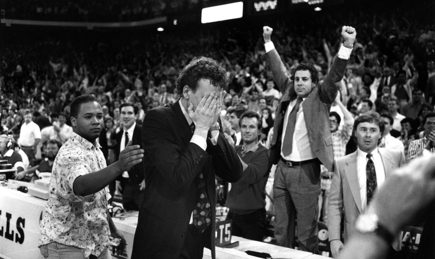 Black and white photograph of Chicago Bulls coach Doug Collins putting his hands to his face in front of the scorers table during a game.