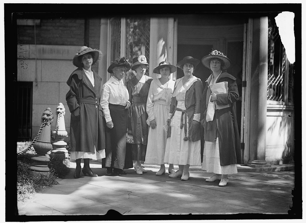 Group of six suffragist women stand outside