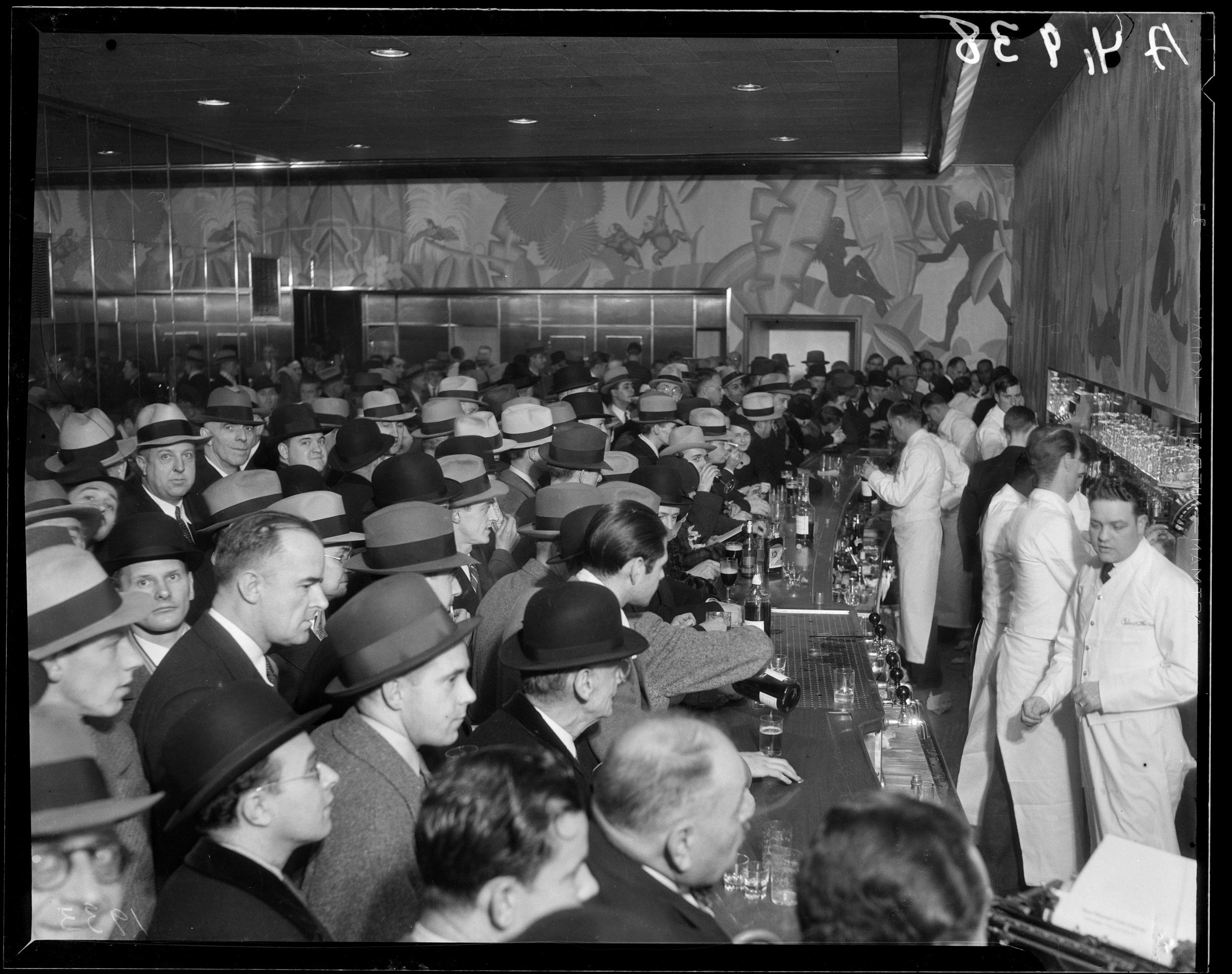 Crowds jamming the bar during the repeal of prohibition at the Palmer House Bar, featuring a Balinese scene mural painted by Honore Palmer Jr., inside the Palmer House Hotel located at 17 East Monroe Street, Chicago, Illinois, circa 1934.