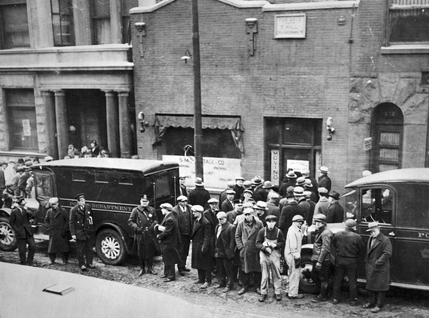 View of crowd and policemen at garage on Clark Street, site of St. Valentine's Day Massacre, c. 1929.