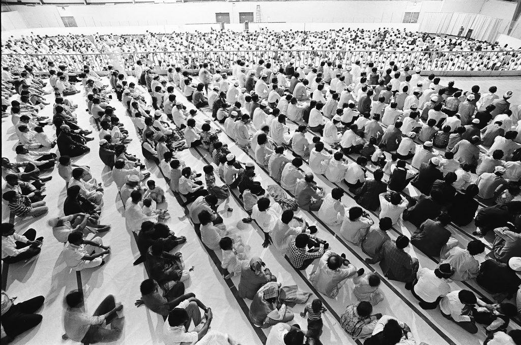 Thousands of Muslims seated in rows celebrate the close of Ramadan in a rented auditorium in the Villa Park suburb in Illinois.