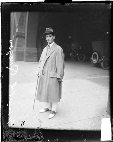 President of the Philippines, Manuel L. Quezon, standing on the corner of a sidewalk