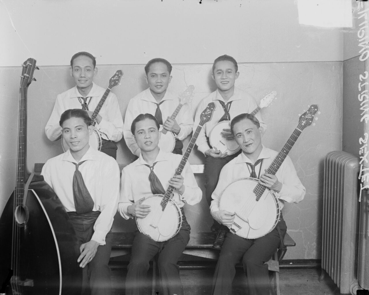 Six members of a Filipino string sextet sitting in a room