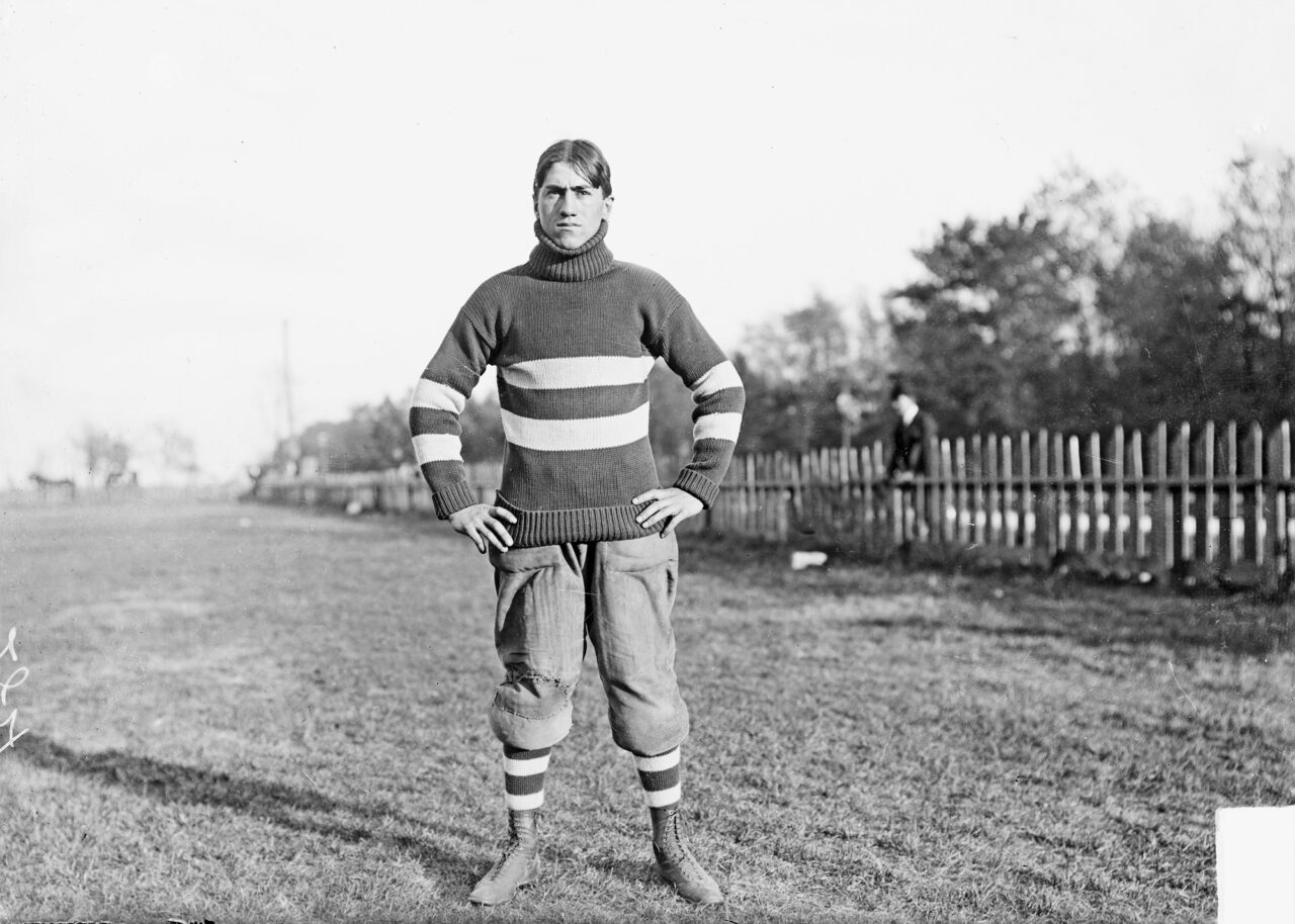 Football player, Walter Eckersall standing, on an athletic field